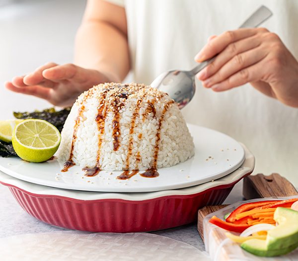 woman-prepares-spring-rolls-with-rice-vegetables-min